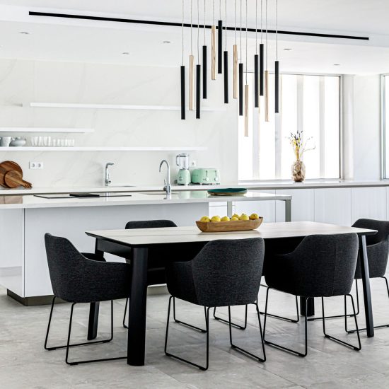 Modern white interior kitchen with brass and black abstract ceiling pendant lighting focal point